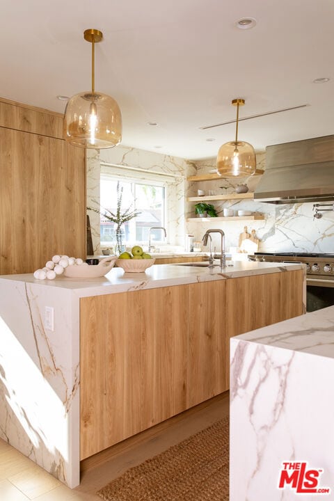 kitchen featuring custom exhaust hood, decorative light fixtures, stainless steel range oven, and decorative backsplash