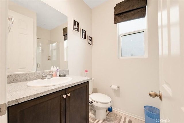 bathroom featuring tile patterned flooring, toilet, a shower with door, and vanity