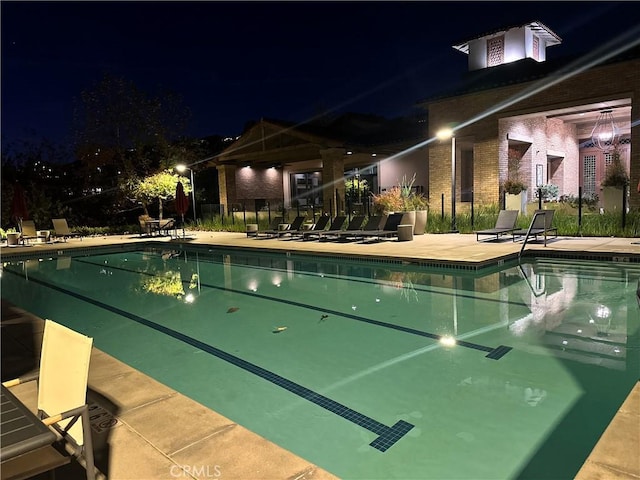 pool at twilight featuring a patio area