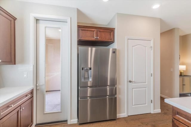 kitchen with wood-type flooring and stainless steel fridge with ice dispenser