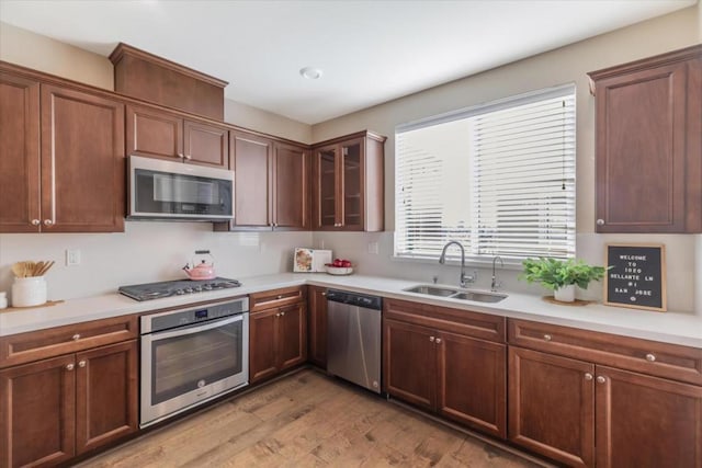 kitchen with light hardwood / wood-style floors, sink, and appliances with stainless steel finishes