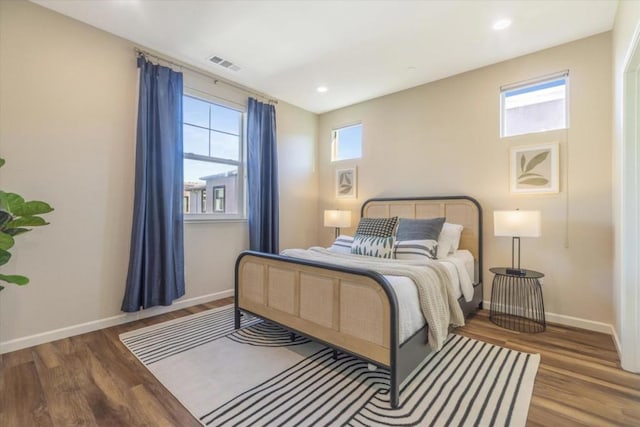 bedroom featuring hardwood / wood-style flooring and multiple windows