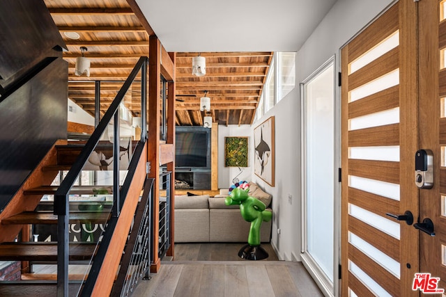 stairway featuring hardwood / wood-style flooring, wooden ceiling, and beam ceiling