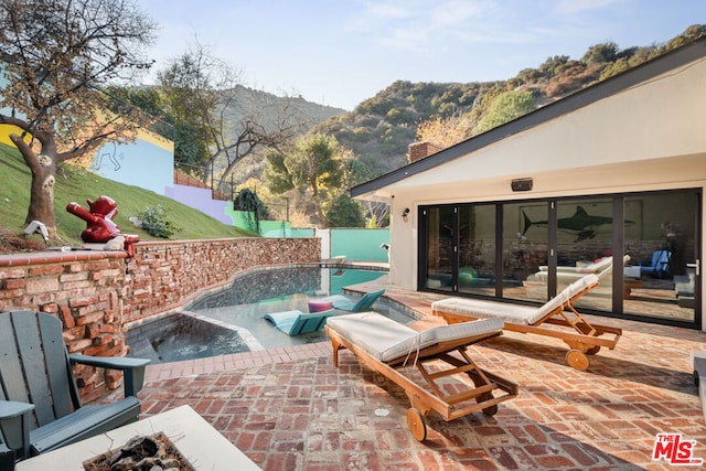 view of patio with a mountain view, a fenced in pool, and an outdoor fire pit