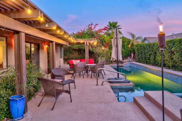 patio terrace at dusk with a fenced in pool