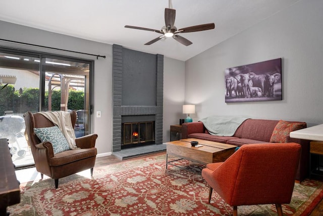 living room with ceiling fan, lofted ceiling, a brick fireplace, and hardwood / wood-style flooring