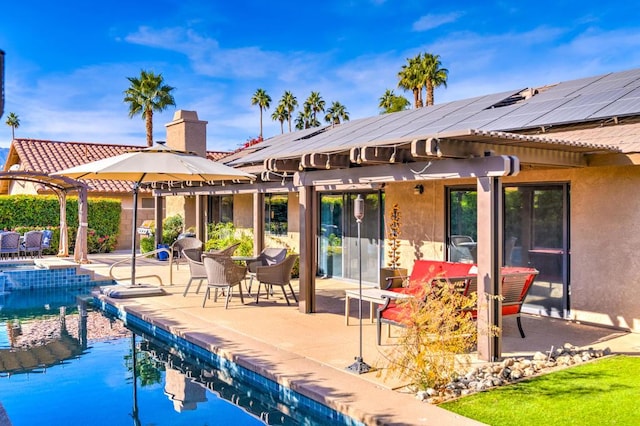 back of property with a patio area and solar panels