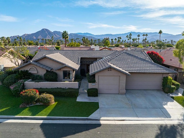 ranch-style house featuring a front yard, a garage, and a mountain view