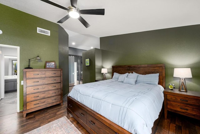 bedroom featuring dark wood-type flooring, ceiling fan, and ensuite bath