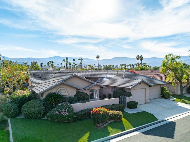 single story home with a front yard, a garage, and a mountain view