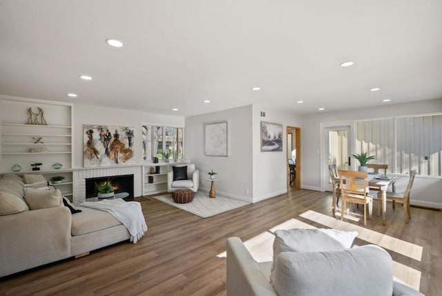 living room with a fireplace and light wood-type flooring