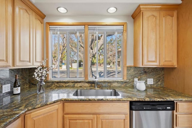 kitchen with sink, dark stone counters, stainless steel dishwasher, and light brown cabinets