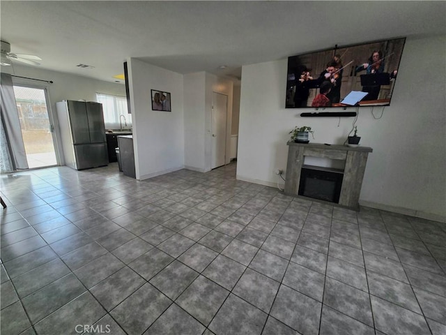 unfurnished living room with tile patterned floors and ceiling fan