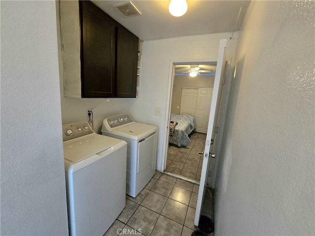 laundry room featuring washing machine and dryer, cabinets, ceiling fan, and light tile patterned flooring