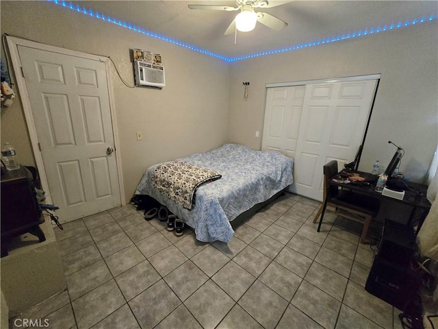 bedroom featuring ceiling fan, tile patterned flooring, a closet, and an AC wall unit