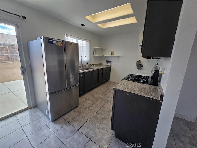 kitchen with light tile patterned flooring, stainless steel fridge, sink, and stove