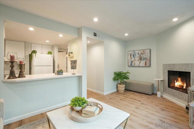 interior space with light wood-type flooring and a fireplace