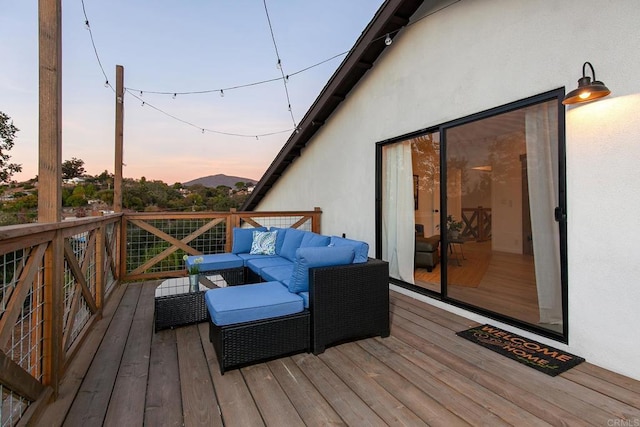 deck at dusk featuring an outdoor hangout area