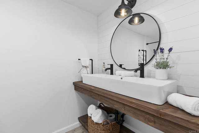 bathroom featuring wood walls and vanity