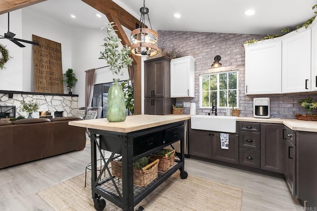 kitchen featuring sink, white cabinets, tasteful backsplash, and vaulted ceiling