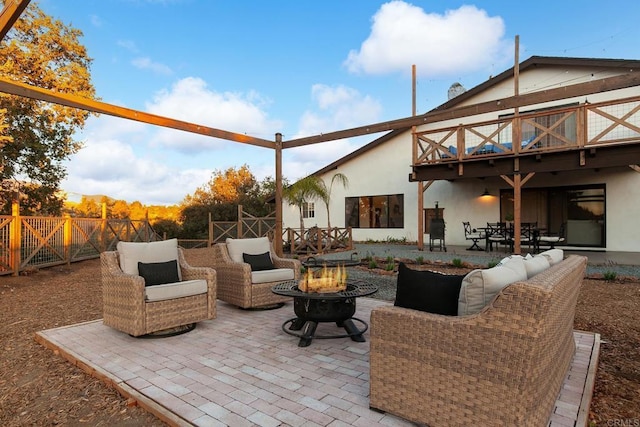 view of patio with an outdoor living space with a fire pit