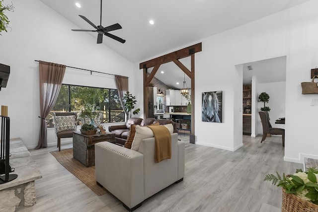 living room with light hardwood / wood-style floors, high vaulted ceiling, and ceiling fan with notable chandelier