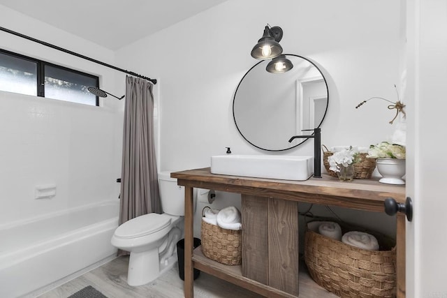 full bathroom with toilet, shower / bath combo, hardwood / wood-style flooring, and sink