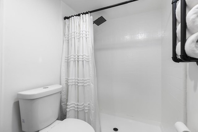 bathroom featuring toilet and a shower with curtain