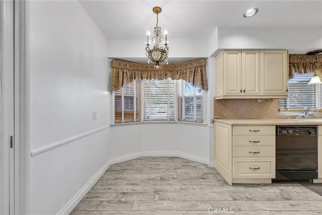 kitchen featuring black dishwasher, a chandelier, hanging light fixtures, light hardwood / wood-style floors, and cream cabinets