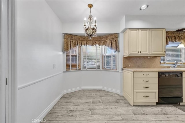 kitchen with black dishwasher, cream cabinets, light wood-style floors, light countertops, and a chandelier