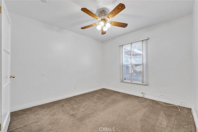 carpeted empty room with a ceiling fan and baseboards