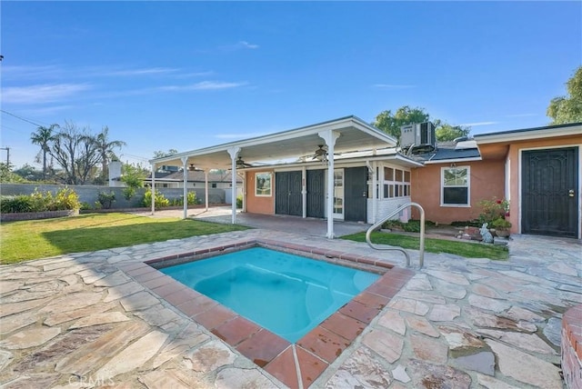 view of pool with a yard, a patio, a sunroom, central air condition unit, and a jacuzzi