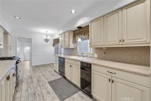 kitchen featuring decorative light fixtures, dishwasher, stainless steel stove, and cream cabinetry