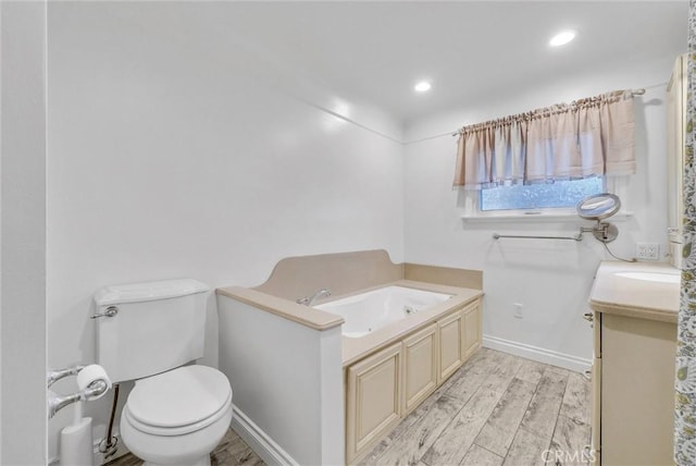 bathroom featuring wood-type flooring, a bath, vanity, and toilet