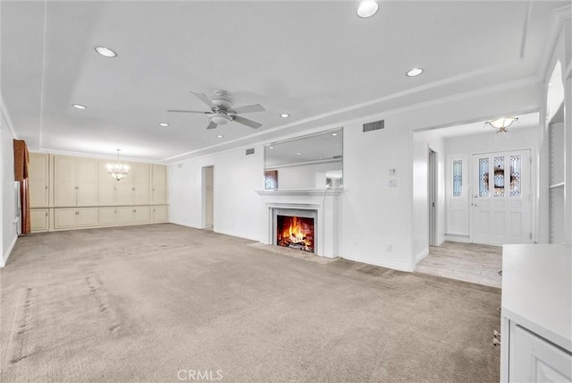 unfurnished living room featuring light colored carpet and ceiling fan with notable chandelier