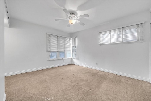 spare room featuring light carpet and ceiling fan