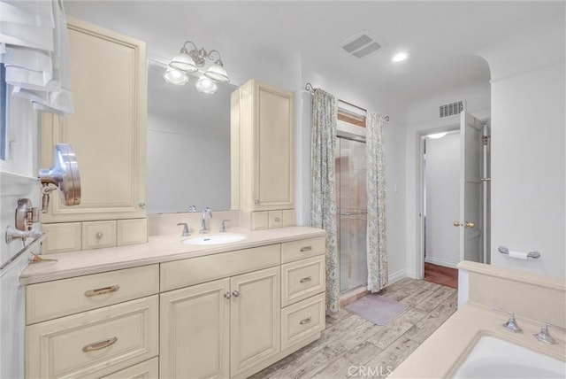 bathroom featuring visible vents, a stall shower, vanity, and wood finished floors