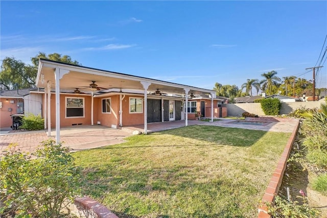 rear view of property with a patio area, ceiling fan, and a lawn