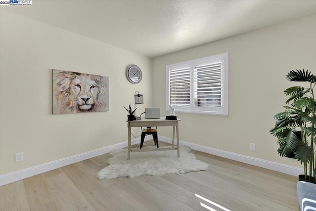 home office with light hardwood / wood-style floors