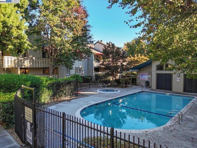 view of swimming pool featuring a community hot tub