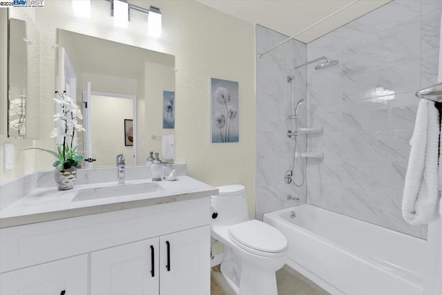 full bathroom featuring toilet, tiled shower / bath, and vanity