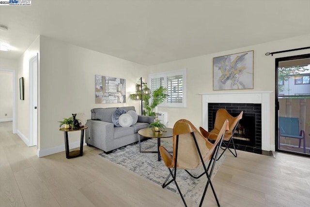 living room featuring light hardwood / wood-style floors and a tiled fireplace