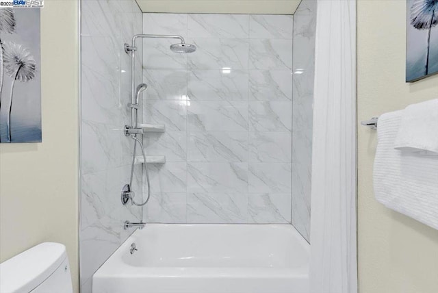 bathroom featuring toilet and tiled shower / bath combo