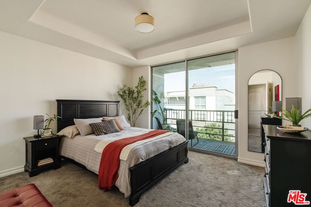 carpeted bedroom featuring a raised ceiling, access to outside, and multiple windows