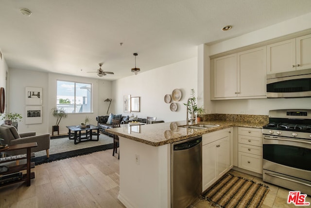 kitchen with ceiling fan, appliances with stainless steel finishes, kitchen peninsula, and cream cabinets