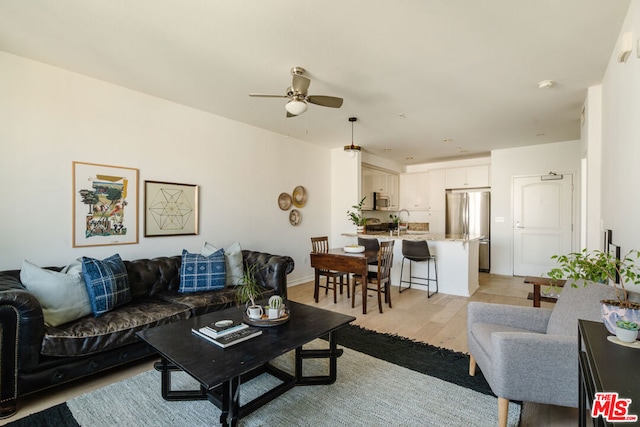 living room with light hardwood / wood-style floors and ceiling fan