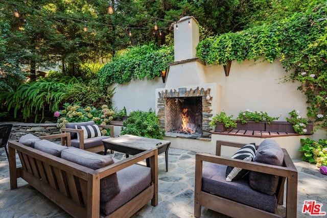 view of patio featuring an outdoor living space with a fireplace