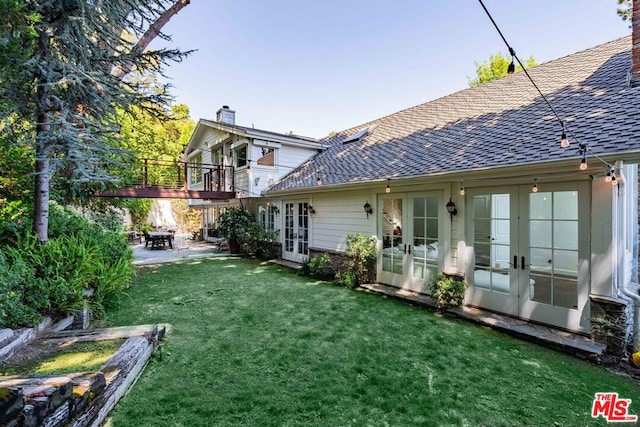 back of house featuring a lawn, french doors, and a patio