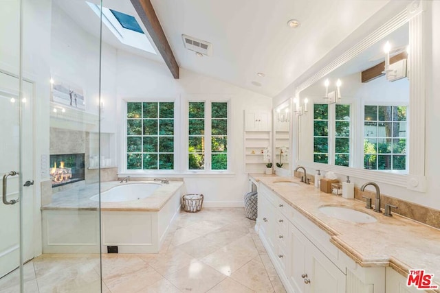 bathroom with shower with separate bathtub, a healthy amount of sunlight, lofted ceiling with skylight, and vanity