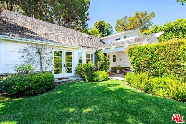 back of house with french doors and a lawn